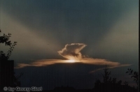 Sonnenuntergang hinter sich auflösender Gewitterwolke